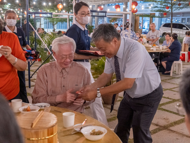 Volunteers present guests with a bag of fresh round fruits and tokens of good luck, as well as a special gift from Master Cheng Yen: an ampao with a commemorative coin and three grains of rice representing wisdom, discipline, and determination. 【Photo by Matt Serrano】