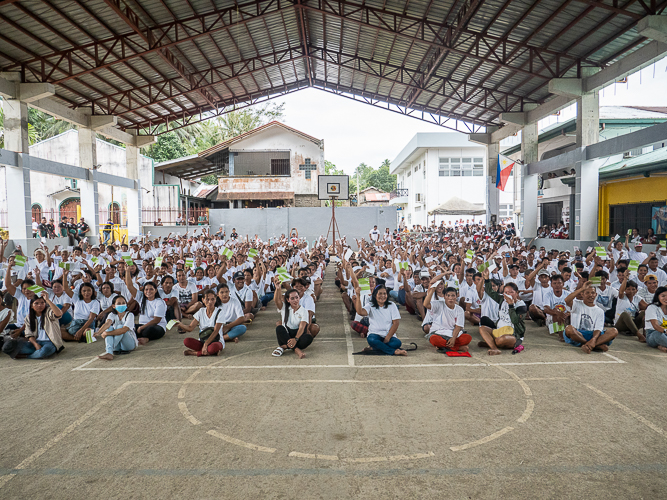 On the day of the relief distribution, residents of Brgy. Polangi joyfully raise their stubs. 【Photo by Matt Serrano】