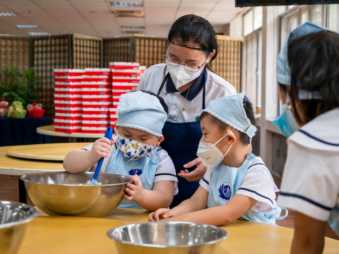 Teacher MJ Seno leads Preschooler Aidan Ongcarranceja and classmates in Tikoy making. 【Photo by Daniel Lazar】