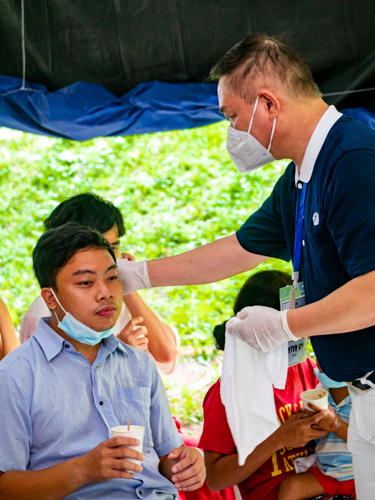 Tzu Chi volunteer wipes patient Nathaniel Glenn Gupana’s face with a clean towel. 【Photo by Daniel Lazar】