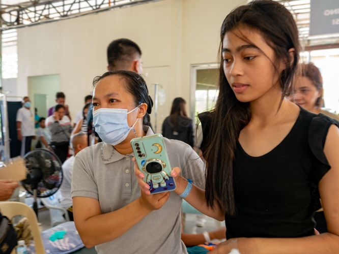 “In Tzu Chi, there really is a touch of care with our patients,” says, Roxanne Ruby Siason (left), a nurse and a Tzu Chi volunteer of 10 years from General Santos City.  “It’s tiring, but it makes me happy. And when they say thank you, it humbles me.” 【Photo by Daniel Lazar】