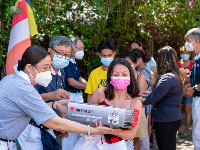 Tzu Chi volunteers distribute gas stove, casserole, 10 kilos of rice, and other cooking needs and hygiene supplies to 106 families in Brgy. UP Campus, Village A. 【Photo by Daniel Lazar】