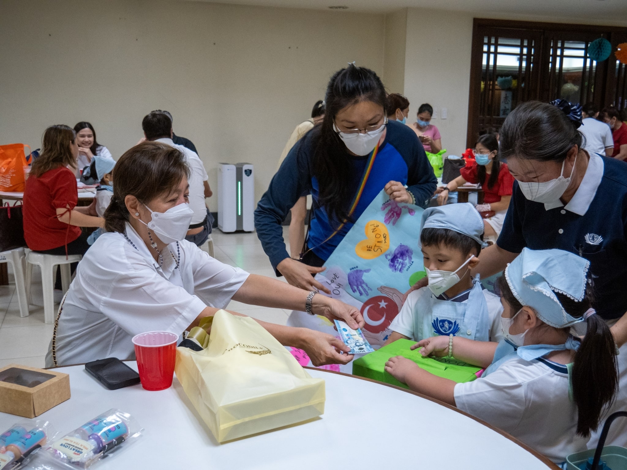With guidance from parents and Tzu Chi volunteers, Preschool students seek donation from guests at the kiddie market.【Photo by Jeaneal Dando】