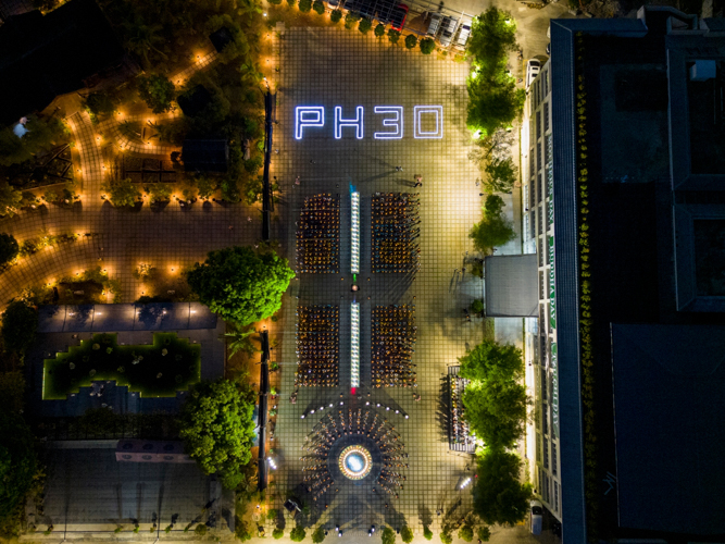 Drone shot of the closing ceremony where attendees raise their lotus candles and sing a prayer for peace.