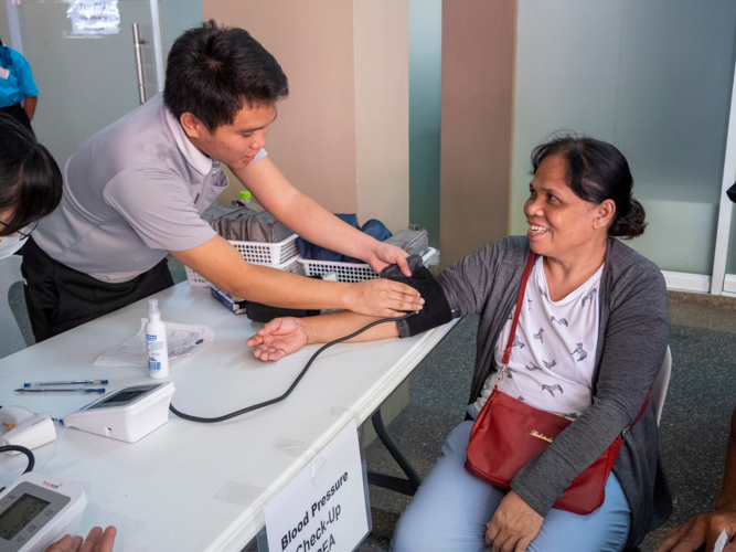 A patient’s vital signs are monitored by a volunteer before treatment.