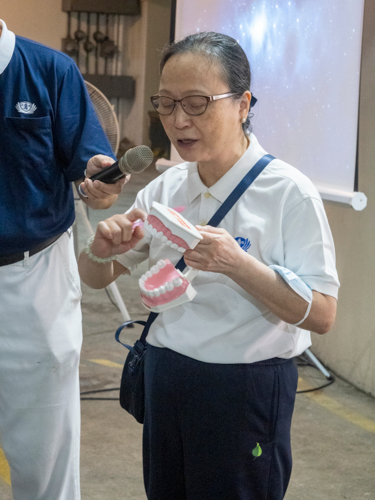 Dr. Cheung Lai Chun demonstrates to beneficiaries the proper way to brush teeth.