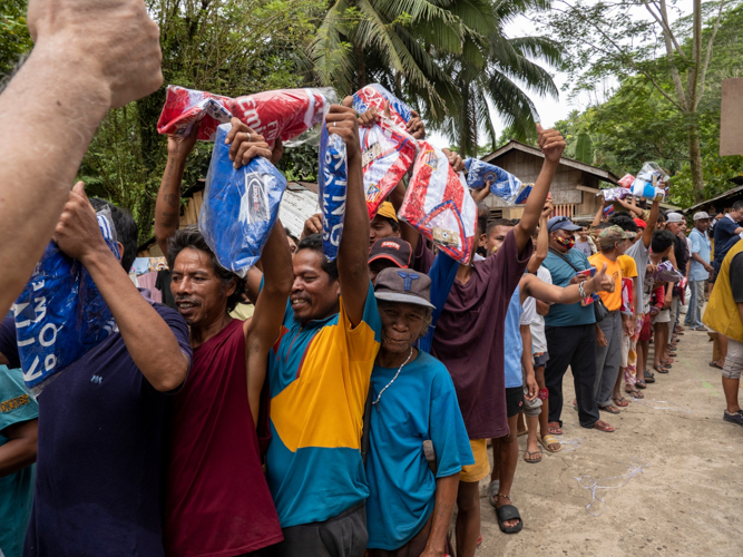 The farmers express their joy and gratitude as they receive shirts and other gifts from Tzu Chi volunteers. 【Photo by Matt Serrano】