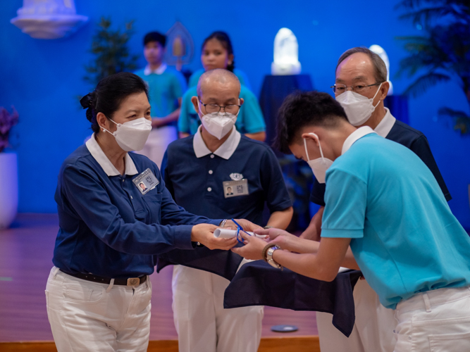 Education committee volunteer Rosa So awards symbolic diploma to a Tzu Chi graduate. 【Photo by Daniel Lazar】