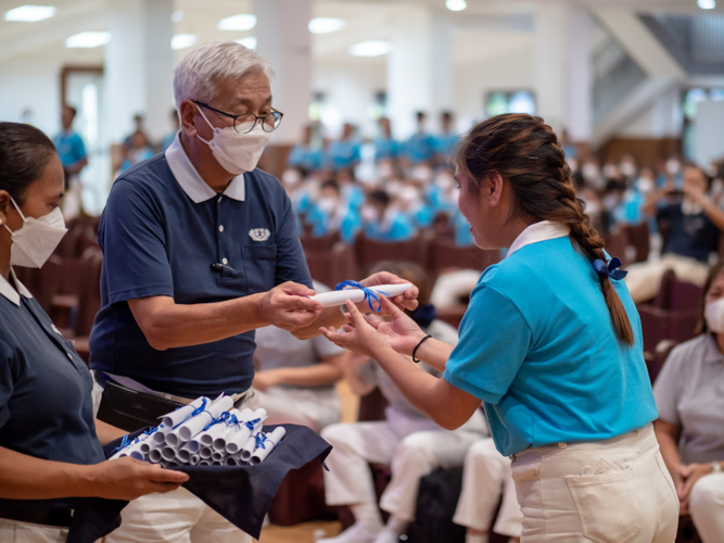 Tzu Chi Philippines CEO Henry Yuñez awards symbolic diploma to a Tzu Chi graduate. 【Photo by Daniel Lazar】