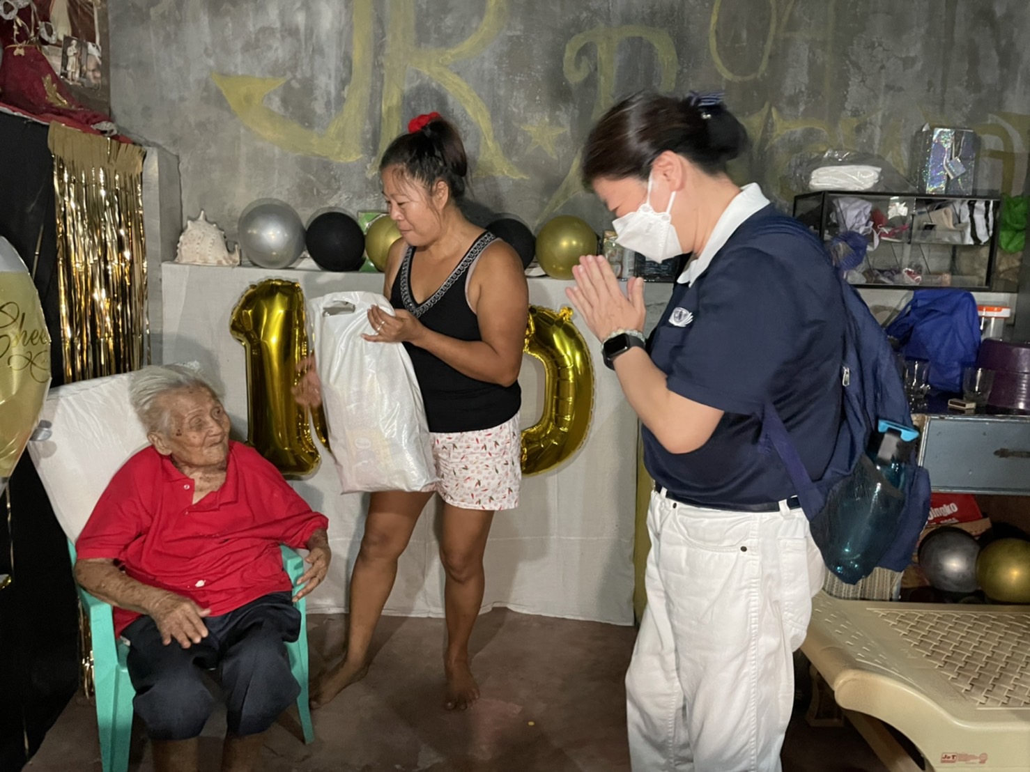 Tzu Chi volunteers visited long-time beneficiary Socorro Bello to celebrate her 100th birthday. They surprised the centenarian with a bag of groceries, rice, cash allowance, and birthday cake. 【Photo by Jeaneal Dando】