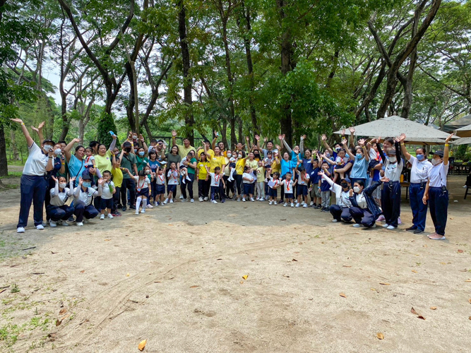 Students, parents, teachers, and volunteers wave to the camera for a group photo. 【Photo by Matt Serrano】