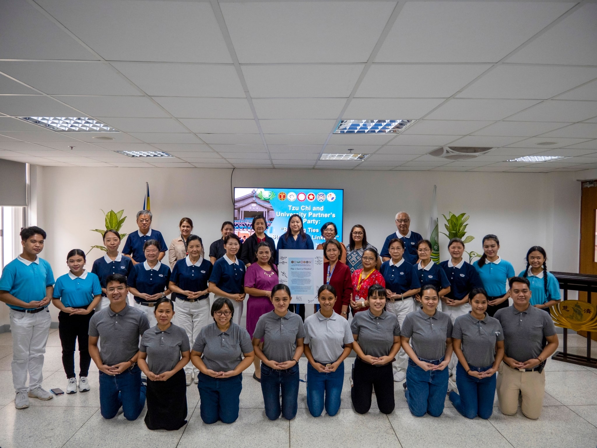 Tzu Chi volunteers, staff, scholars, and university partners pose for a group a photo.