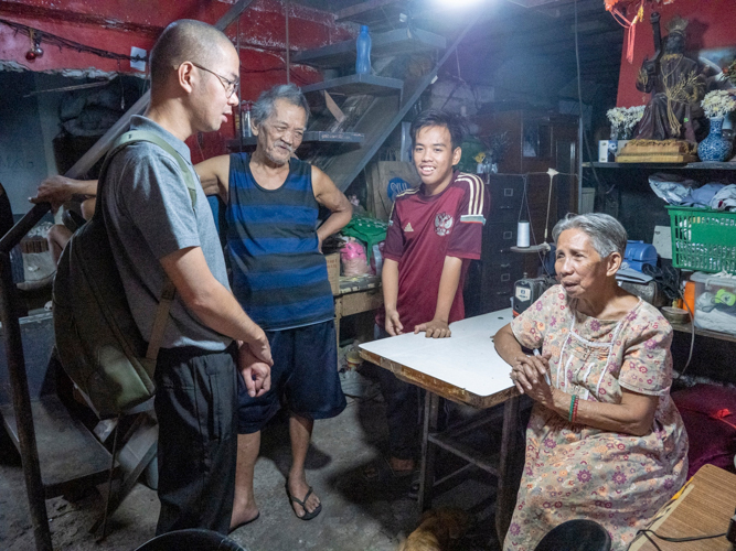 Wilbert Tolentino and his grandparents chat with Tzu Chi volunteers during a home visit. 【Photo by Matt Serrano】