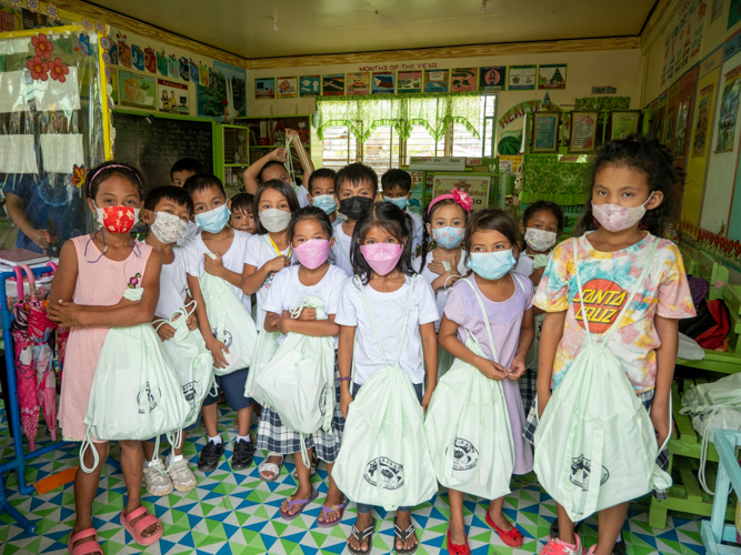 Students pose for a photo with their new school bags. 【Photo by Matt Serrano】