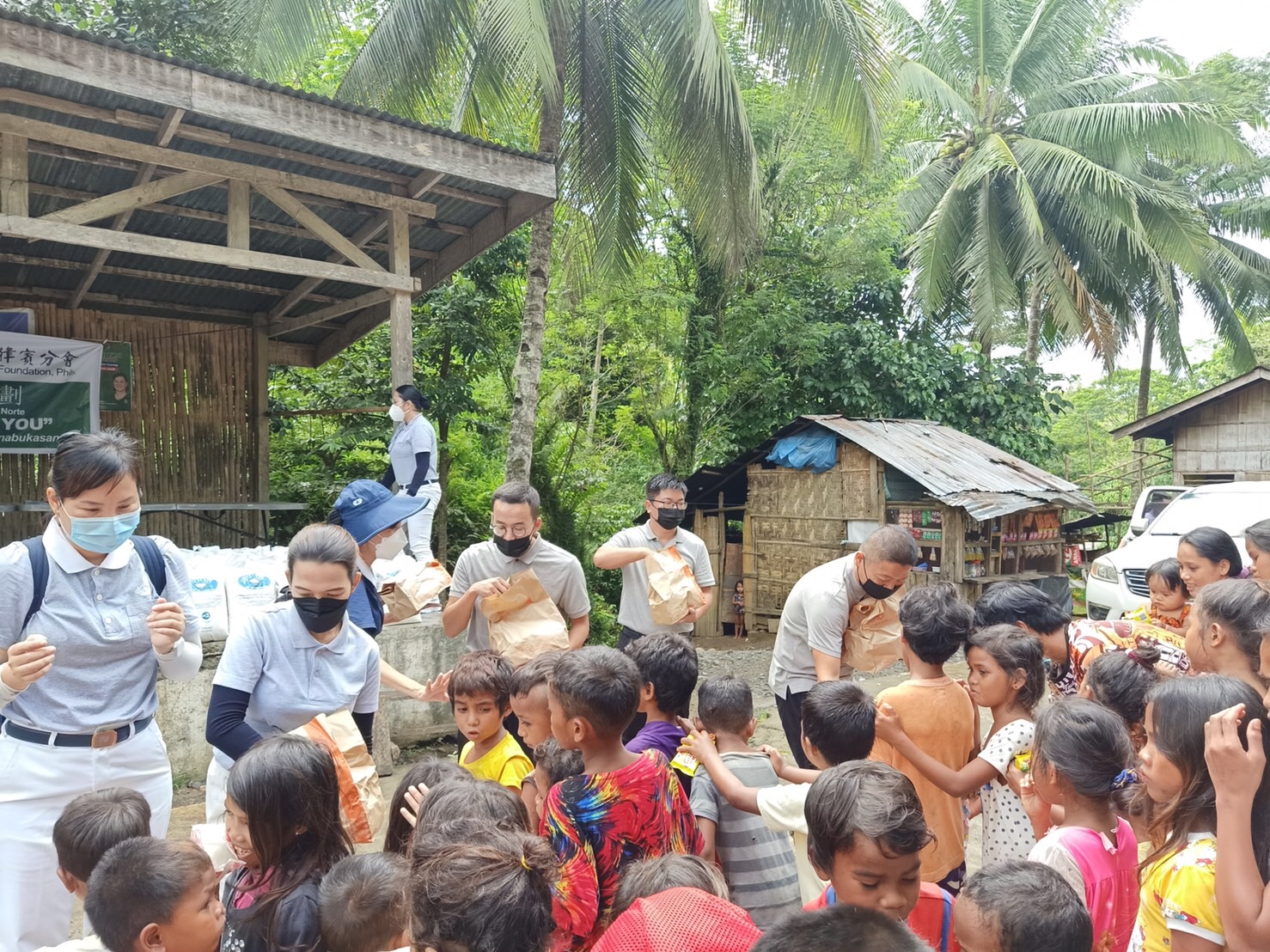 Volunteers distribute vegetable buns and candies to the farmers’ children.