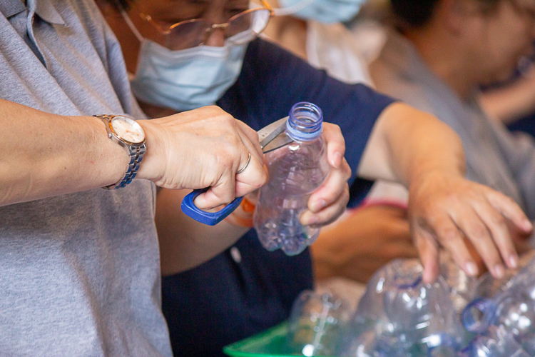 Volunteers work together to make lotus flower candles out of collected PET bottles. 【Photo by Marella Saldonido】