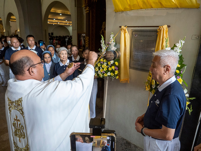 Rev. Fr. Kelvin M. Apurillo, with Tzu Chi Philippines CEO Henry Yuñez (right), leads the unveiling of a marker at the church’s entrance, a testament to the gratitude of the Sto. Niño Church toward the Tzu Chi Foundation, which helped rebuild the church in 2014 after it was destroyed by Super Typhoon Yolanda. 【Photo by Matt Serrano】