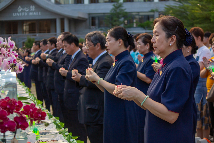 Volunteers offer candles as symbols of inner light and gratitude to the Buddha, loved ones, and all beings.