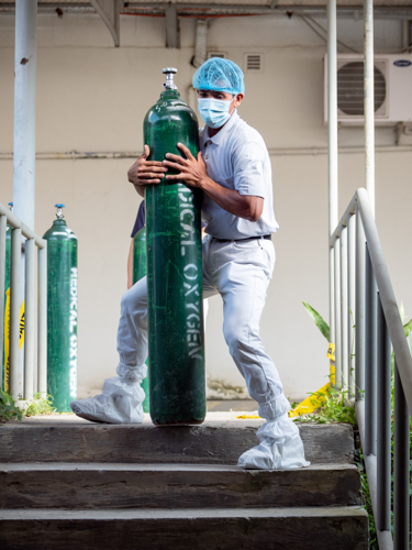 Tzu Chi Zamboanga volunteer Rosaleo Enricoso lifts an oxygen tank to the operating room. 【Photo by Daniel Lazar】
