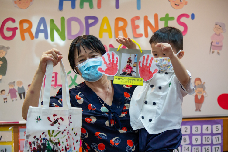 Grandmother and grandson show off their artwork on Grandparents Day. 【Photo by Marella Saldonido】