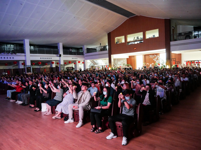 Volunteers and guests raise their candles as they sing a prayer for peace and harmony in the world. 【Photo by Matt Serrano】