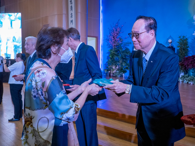 Tzu Chi Bicol head volunteer Antonio Tan presents an angpao to a guest. 【Photo by Matt Serrano】