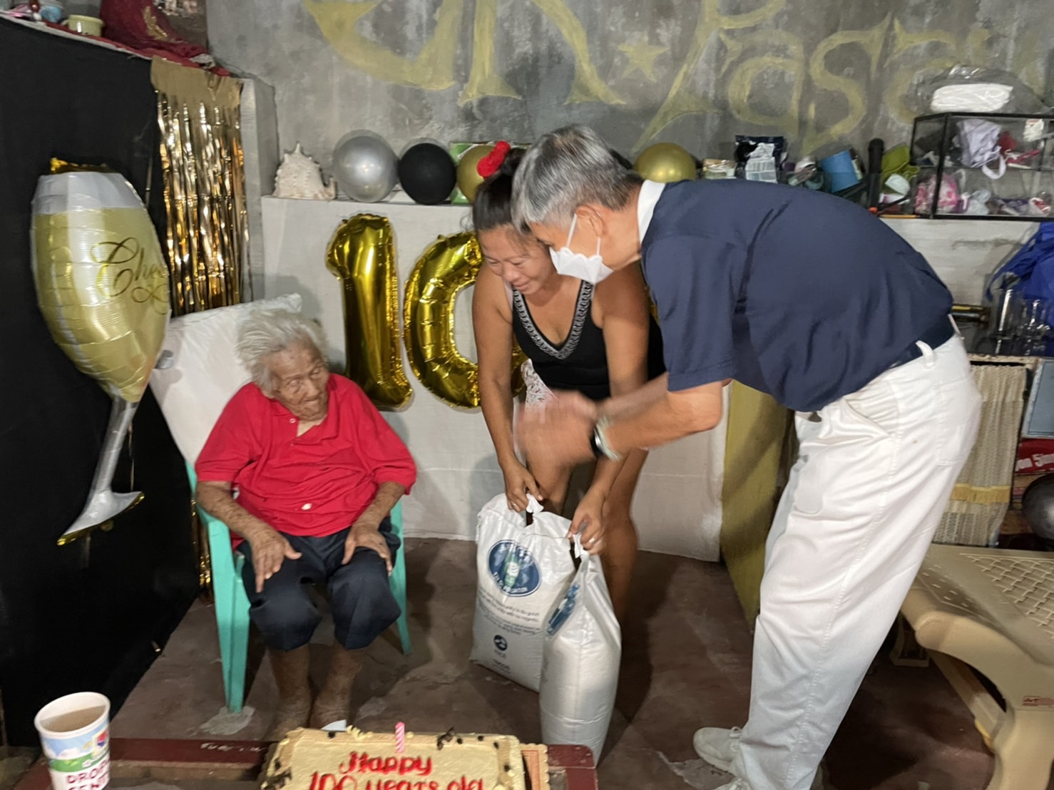 Tzu Chi volunteers visited long-time beneficiary Socorro Bello to celebrate her 100th birthday. They surprised the centenarian with a bag of groceries, rice, cash allowance, and birthday cake. 【Photo by Jeaneal Dando】