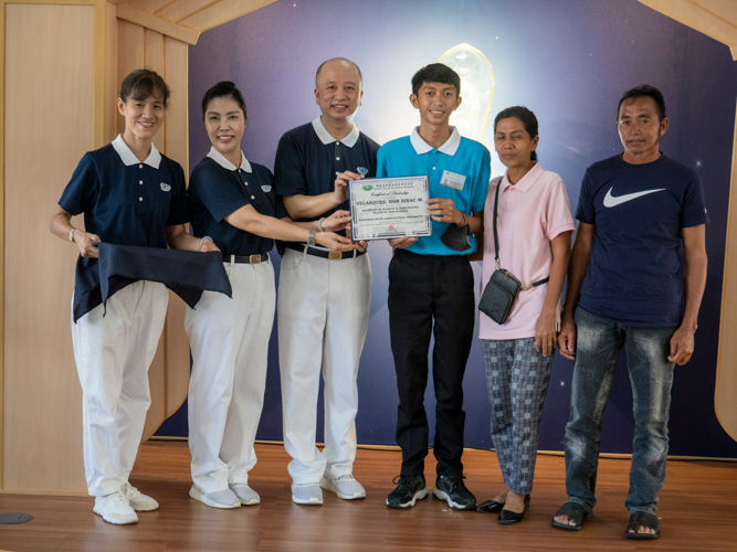 Agriculture student Ron Sirac Velasquez receives his certificate of scholarship. 【Photo by Matt Serrano】