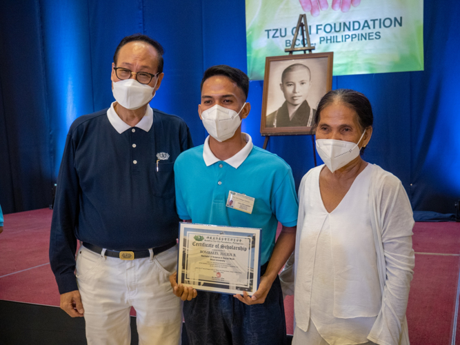 Tzu Chi Bicol head volunteer Antonio Tan with a Tzu Chi scholar and his parent【Photo by Jeaneal Dando】
