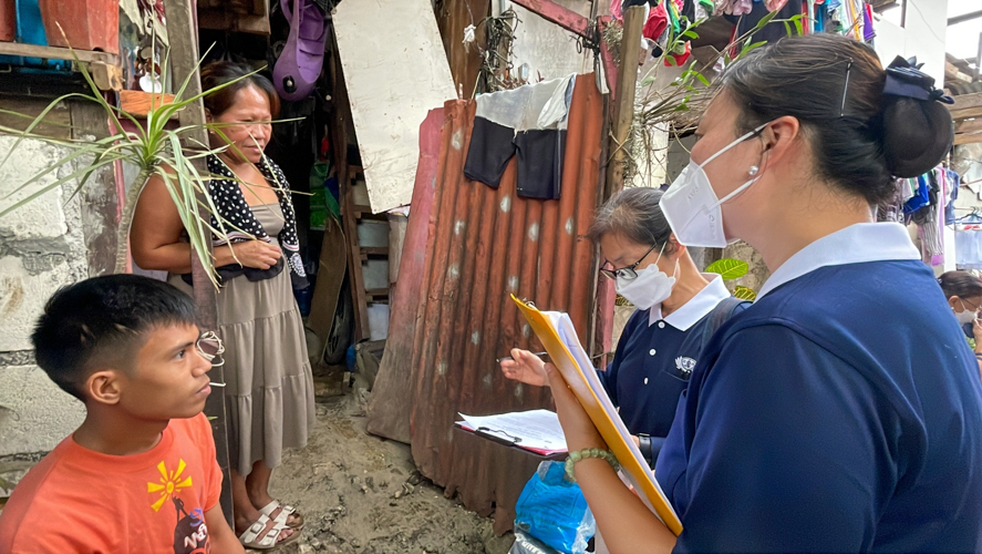 Manila volunteers talk to Shyrwin Rondina and his mother Juana to get to know the family’ socio-economic conditions. 【Photo by Jeaneal Dando】