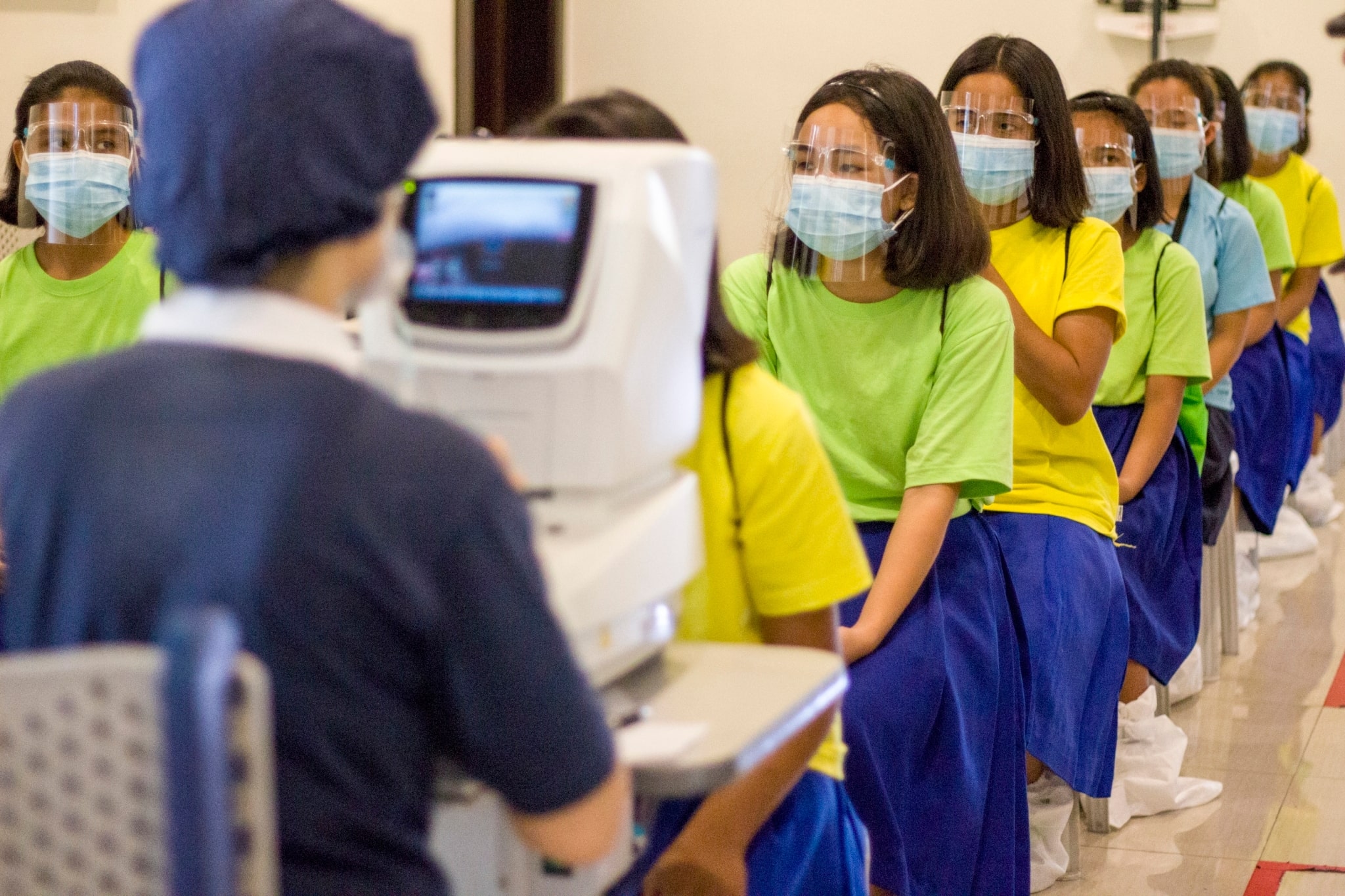 Students line up as they wait their turn for the initial eye checkup.【Photo by Matt Serrano】