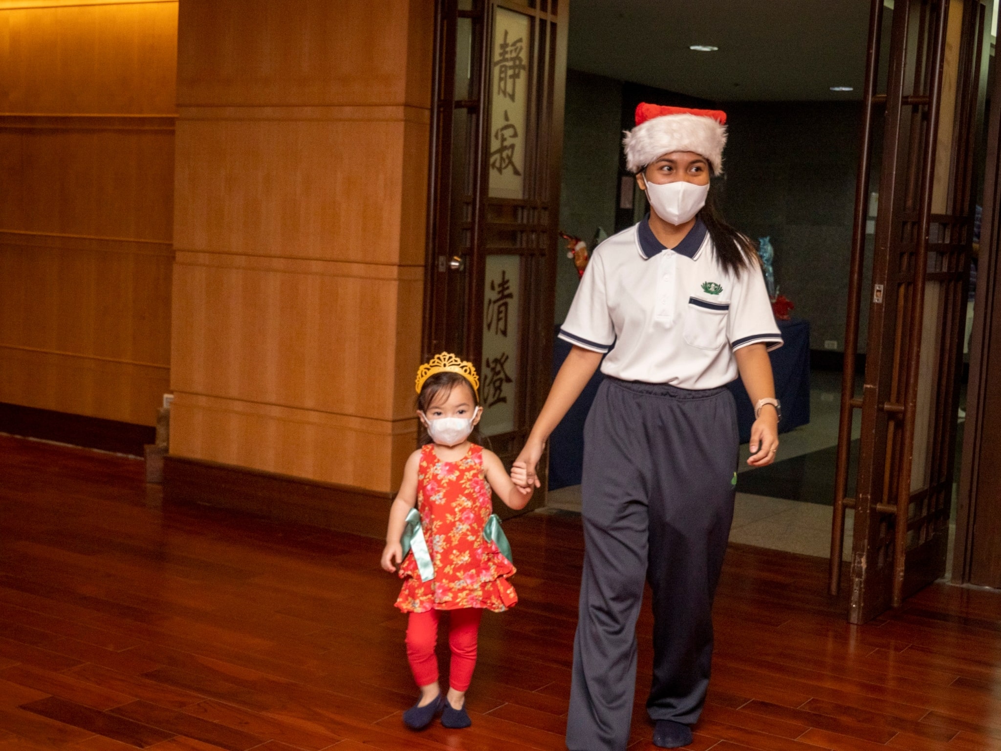 Teacher Christine Pauline Paje guides a student in her entry to the Jing Si Hall. 【Photo by Harold Alzaga】