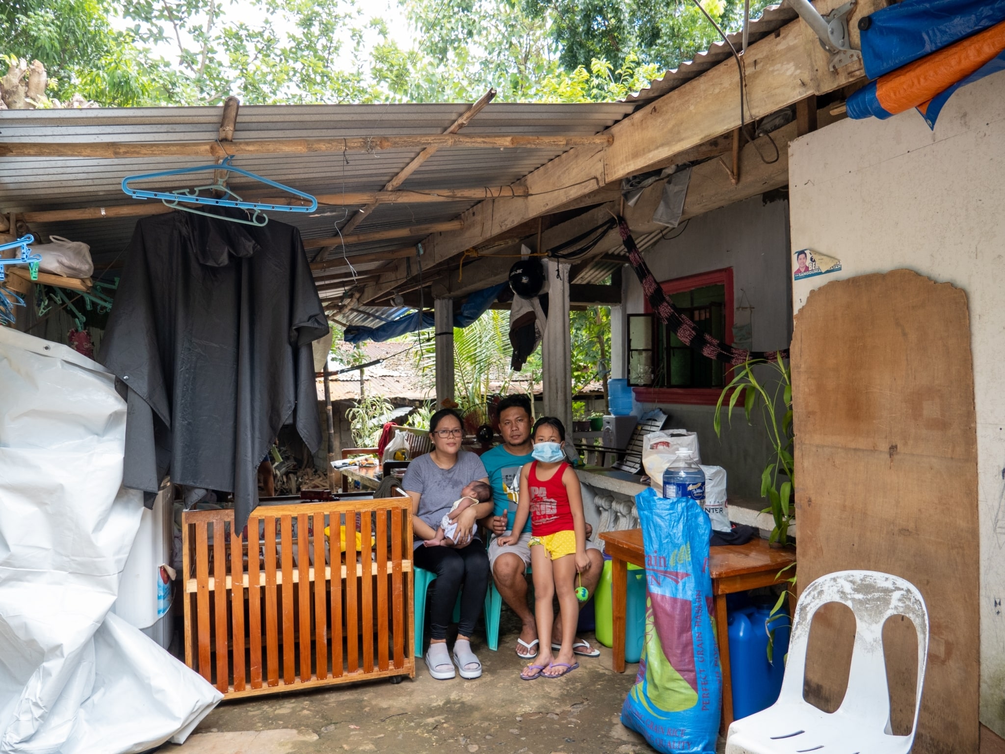 Jener Blanza and his family temporarily stay in a small roofed space in front of her mother-in-law’s house.【Photo by Matt Serrano】