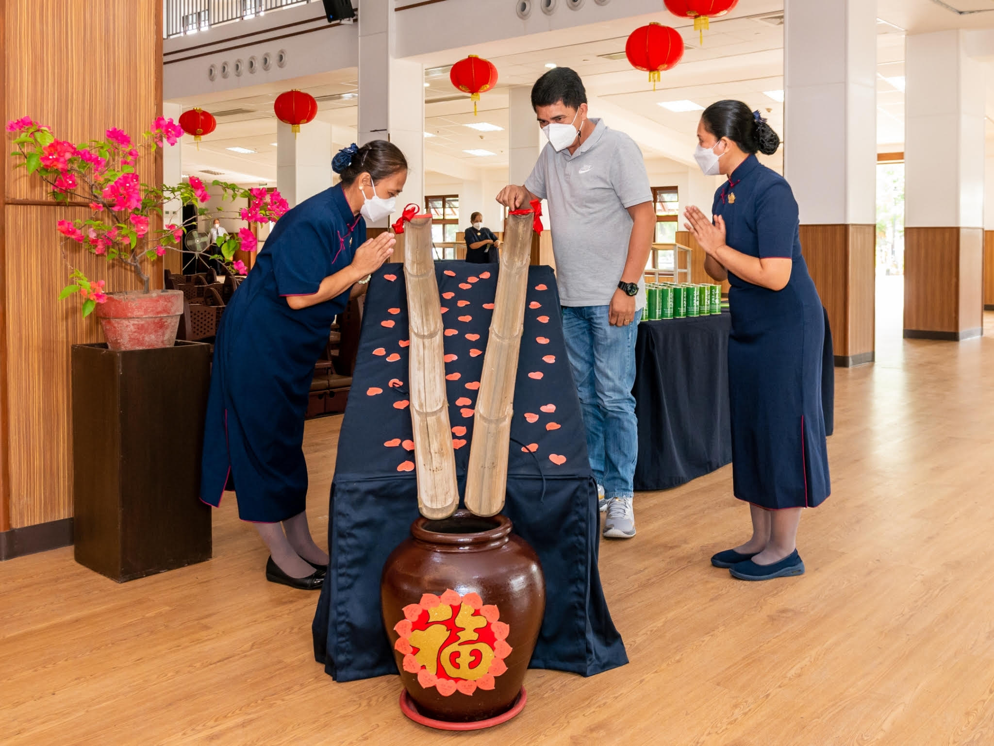 Coins collected by volunteers are dropped on bamboo slides and accumulate in a clay jar. 【Photo by Daniel Lazar】