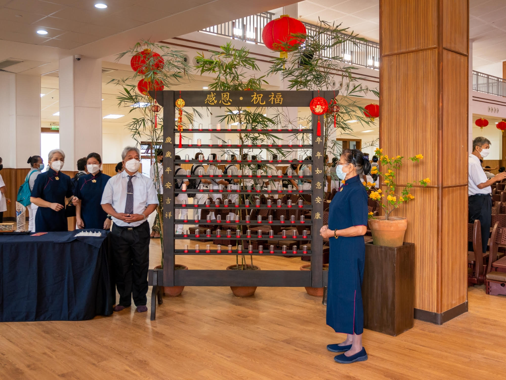 Volunteers invite guests to write their wishes on a piece of paper and place them in one of the bottles of a Wishing Wall. 【Photo by Daniel Lazar】