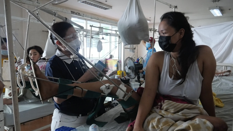 Tzu Chi volunteer Edita Young (left) visits Micholle Manila at the Philippine Orthopedic Center.