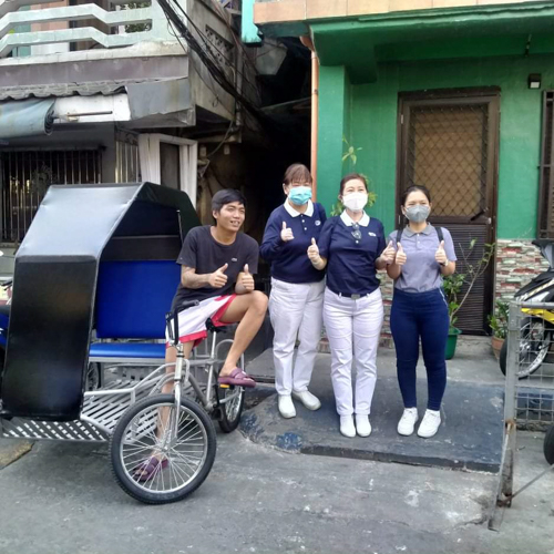 Micholle Manila’s husband Carlo Francisco (first from left) poses with Tzu Cho volunteers and the pedicab he received from them for his livelihood.