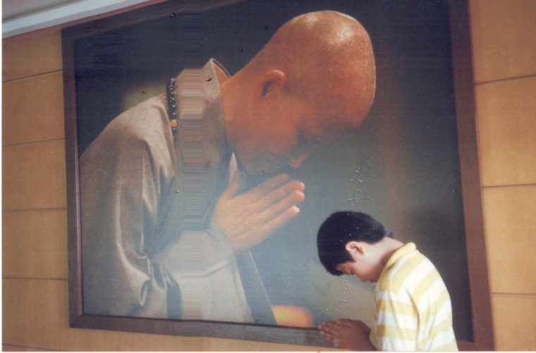 Bowing before Dharma Master Cheng Yen, Kinlon Fan was about 12 or 13 at the time.