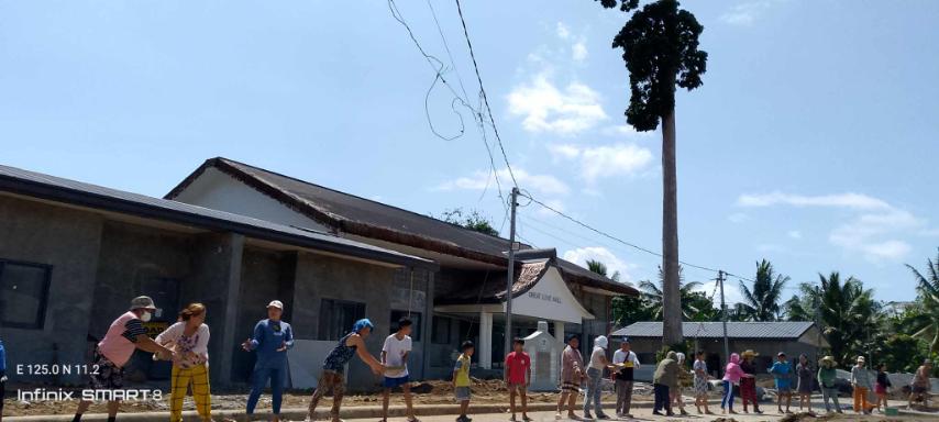 Nothing is impossible when we work together: Palo beneficiaries pass cement tiles to lay on the front of permanent homes in Tzu Chi Great Love Village. 