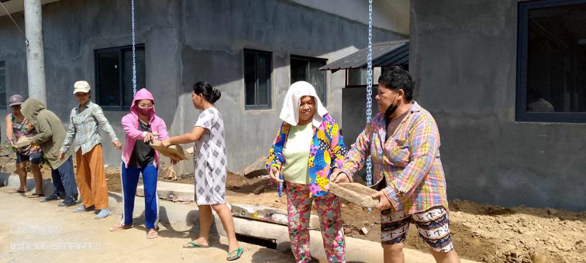 Nothing is impossible when we work together: Palo beneficiaries pass cement tiles to lay on the front of permanent homes in Tzu Chi Great Love Village. 