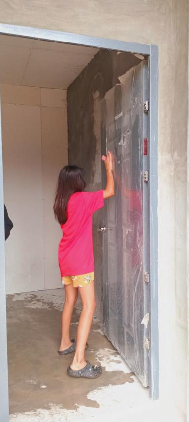 Young girls help wipe windows and doors.