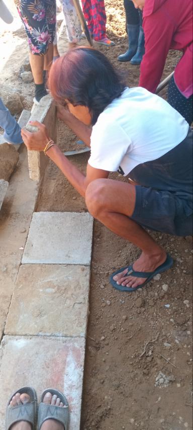 Despite the sweltering heat and holiday, Palo beneficiaries spend their Black Saturday placing tiles on the sidewalks of Tzu Chi Great Love Village.