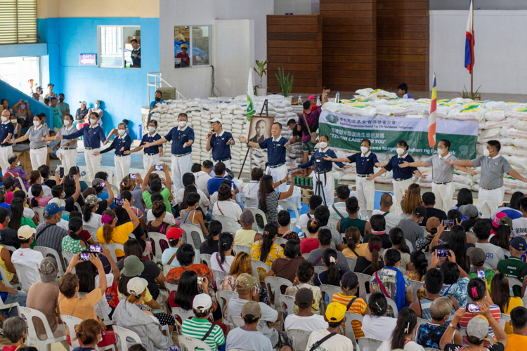 Tzu Chi volunteers lead beneficiaries in a sign language number at the Dingalan Municipal Multipurpose Gymnasium. 【Photo by Matt Serrano】