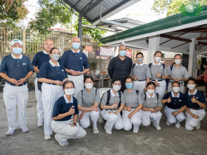 Tzu Chi volunteers and Mother of Divine Providence Parish priest Fr. John Castillo FDP pose for a photo after the successful rice distribution in Payatas, Quezon City. 【Photo by Kendrick Yacuan】