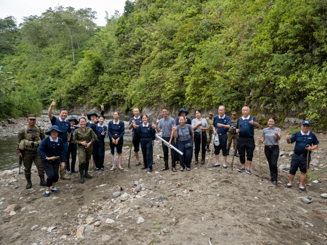 Tzu Chi volunteers pause for a group shot after crossing a river. 【Photo by Matt Serrano】