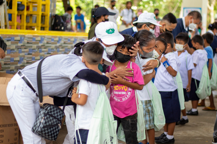 In the spirit of love and compassion, volunteers hug the students as they give them school supplies. 【Photo by Matt Serrano】