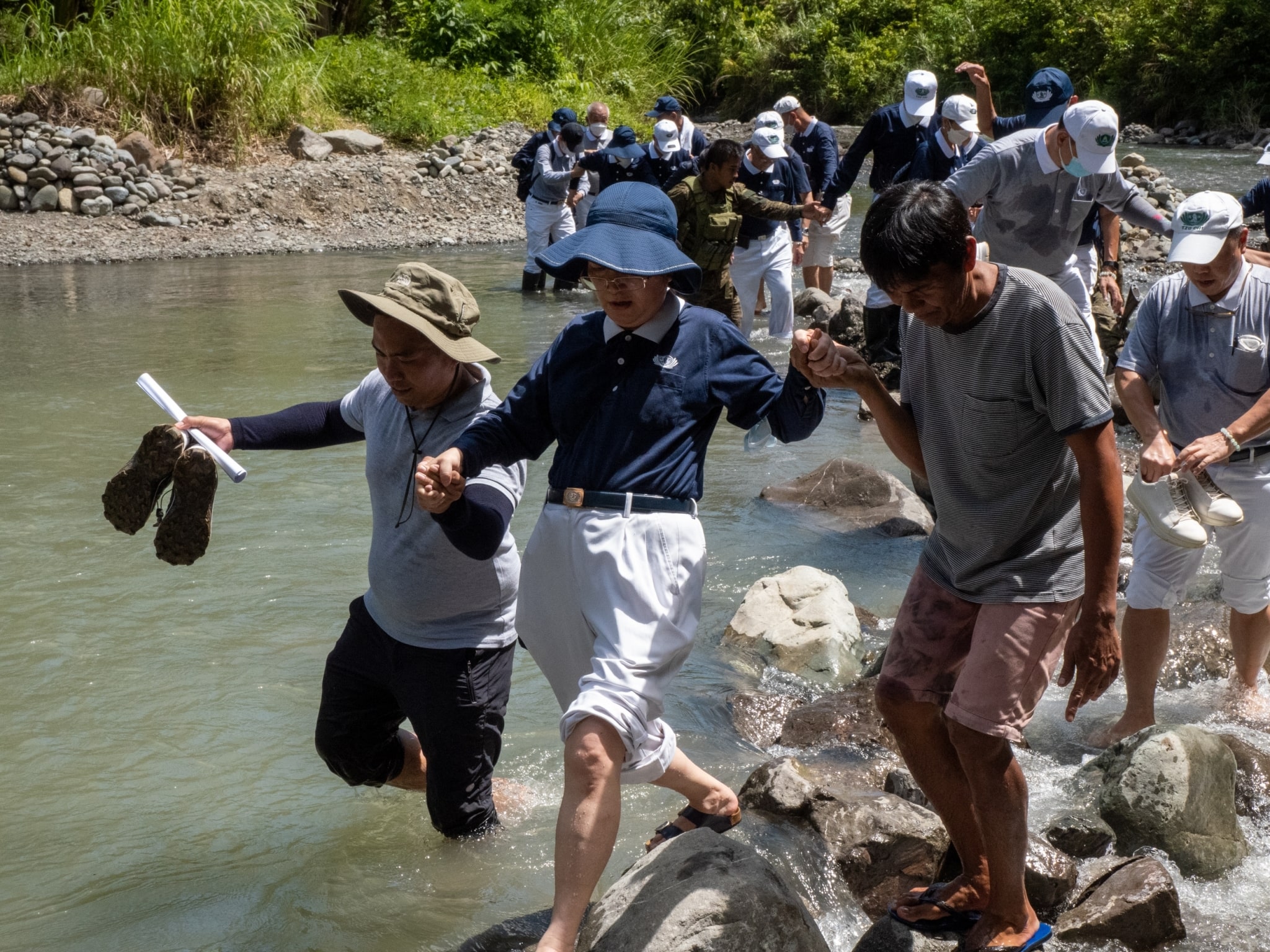 On June 4, 2022, Tzu Chi photographer Matt Adrian Serrano shot volunteers crossing a rocky river to get to Talaingod, a municipality some 130 kilometers away from downtown Davao. There, they presented an indigenous community with 2,500 banana seedlings to start a sustainable livelihood program. This trip was also Matt's first time to travel by plane.【Photo by Matt Serrano】