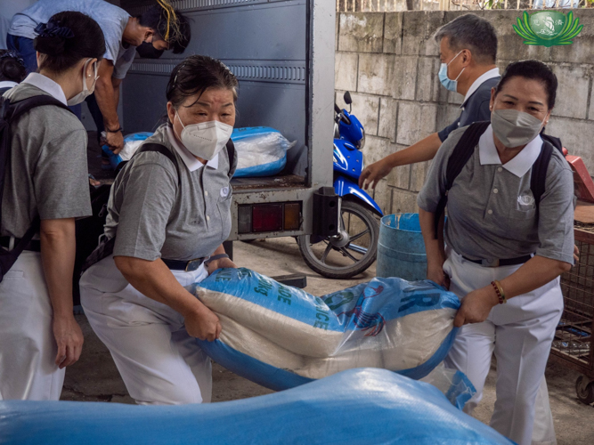 Tzu Chi volunteers unload 100 sacks of rice for distribution to indigent families in Payatas, Quezon City. 【Photo by Kendrick Yacuan】