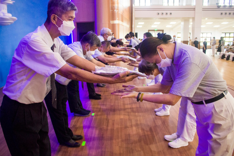 Tzu Chi commissioners award white-collar polo shirts to training volunteers. 【Photo by Matt Serrano】