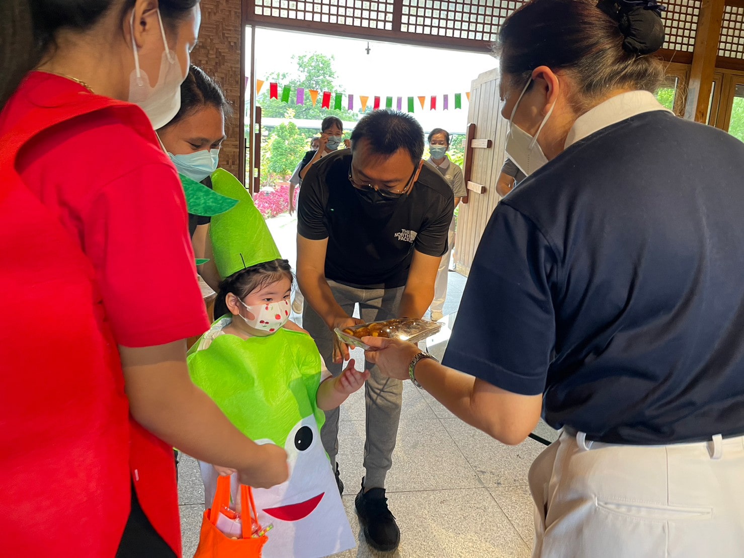 As a gesture of gratitude, student shares a rice cake to Tzu Chi volunteer after receiving her treat. 【Photo by Jeaneal Dando】